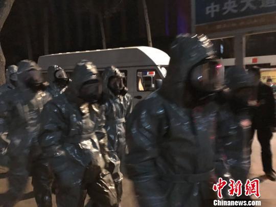 十几名身着防护服的人员头戴面具进入事发地。　胡健 摄
